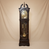 Wooden grandfather clock with intricate design on a white background